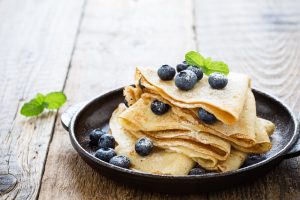 A plate of paleo crepes with blueberries