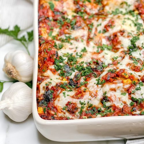 close up of a pan of lasagna topped with melted cheese