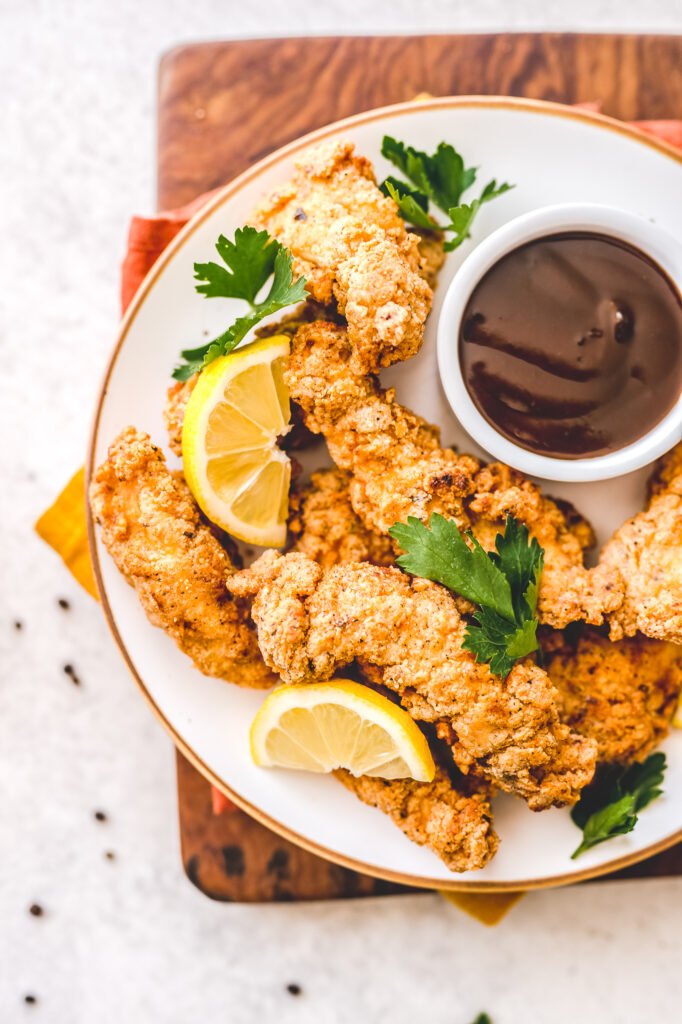 plate of paleo fried chicken with dish of BBQ sauce
