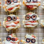 6 sausage patties with cheese strip and olives for eyes to make a "mummy"