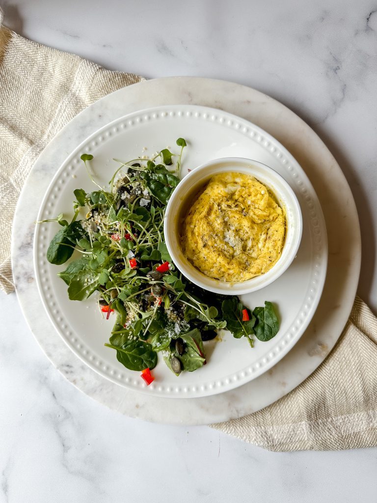 high protein low glycemic breakfast example a plate with green salad and ramekin of baked eggs
