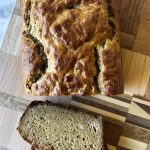 loaf of banana bread on a cutting board with 2 slices