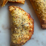 close up photo of a golden brown keto calzone sprinkled with spices