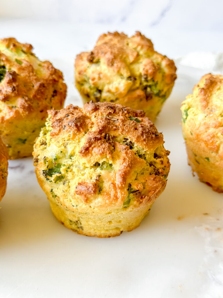 close up of a cheesy, breakfast biscuit loaded with sausage and broccoli