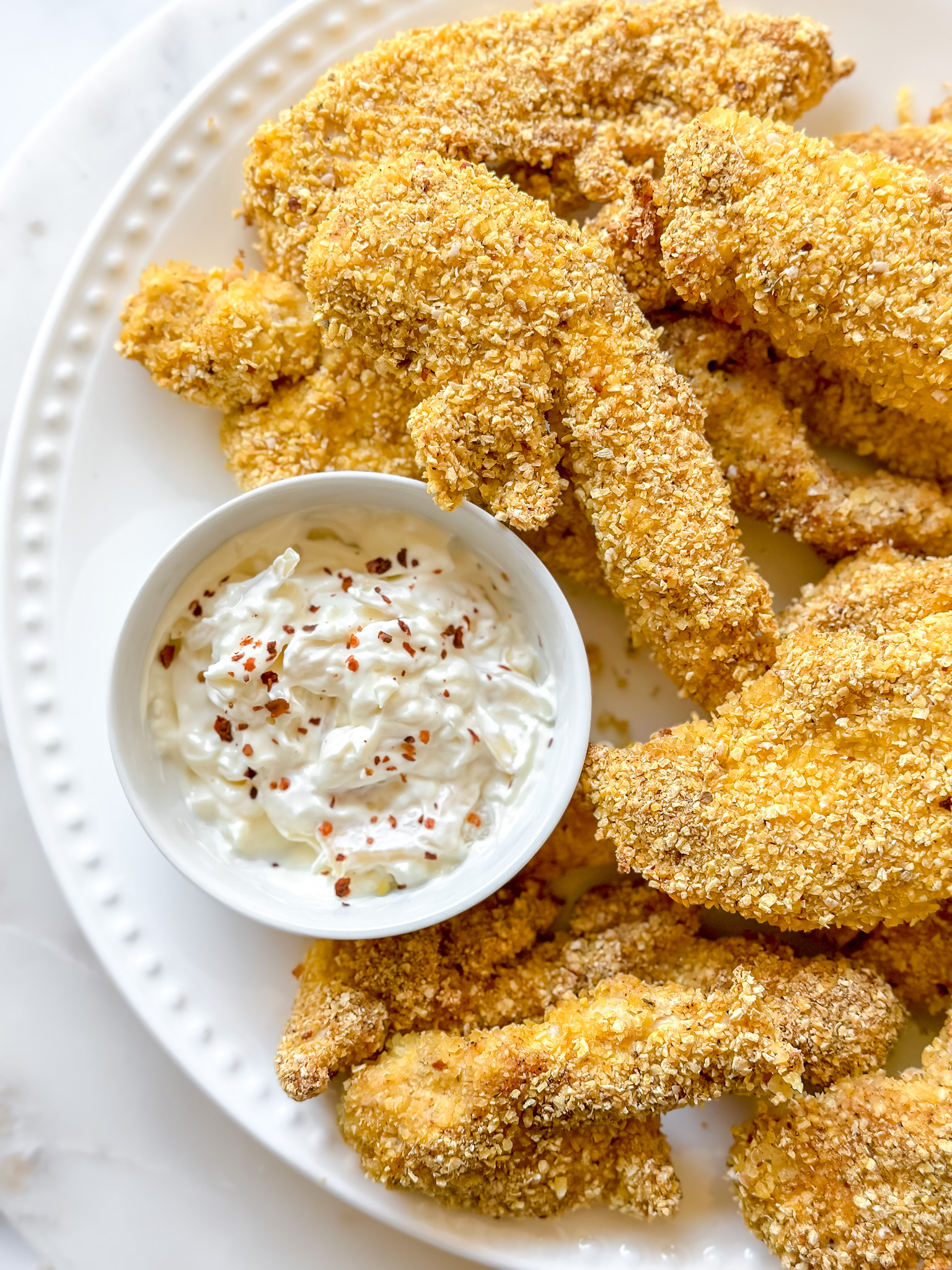 plate of crispy keto chicken tenders with dipping sauce