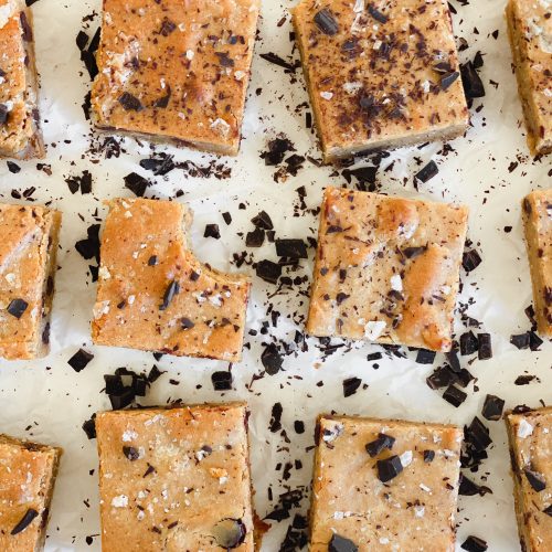 close up of blondies cut in squares and scattered dark chocolate chunks