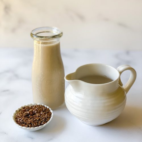 homemade flax milk in jug and creamer plus dish of flax seeds