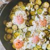 zucchini, feta and eggs in a skillet