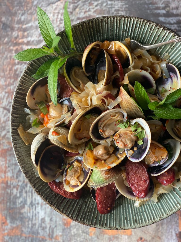 close up of clams with noodles in a bowl