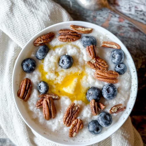 bowl of "cream of wheat" topped with butter, blueberries, and pecans