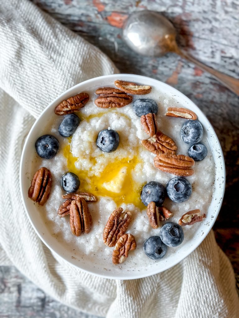 bowl of "cream of wheat" topped with butter, blueberries, and pecans