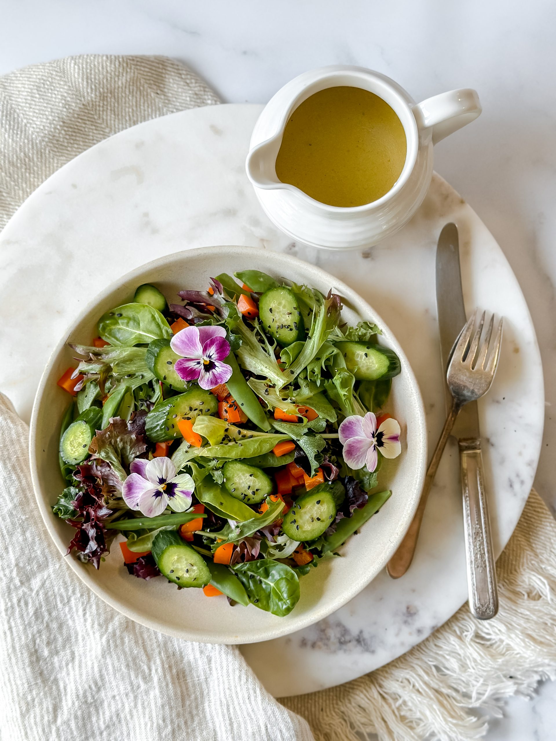 colorful salad with pitcher of miso vinaigrette