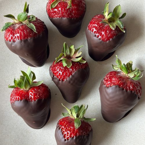 7 dark chocolate dipped strawberries on a plate