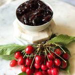 fresh cherries and a bowl of cherry jam