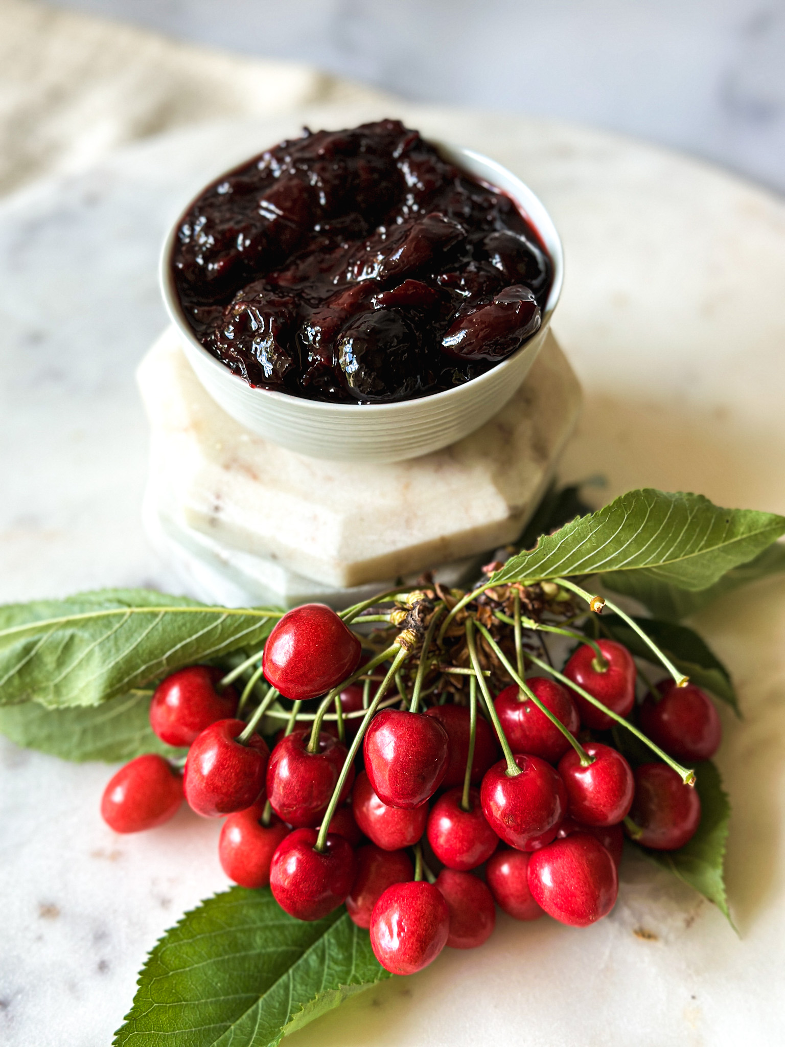 fresh cherries and a bowl of cherry jam