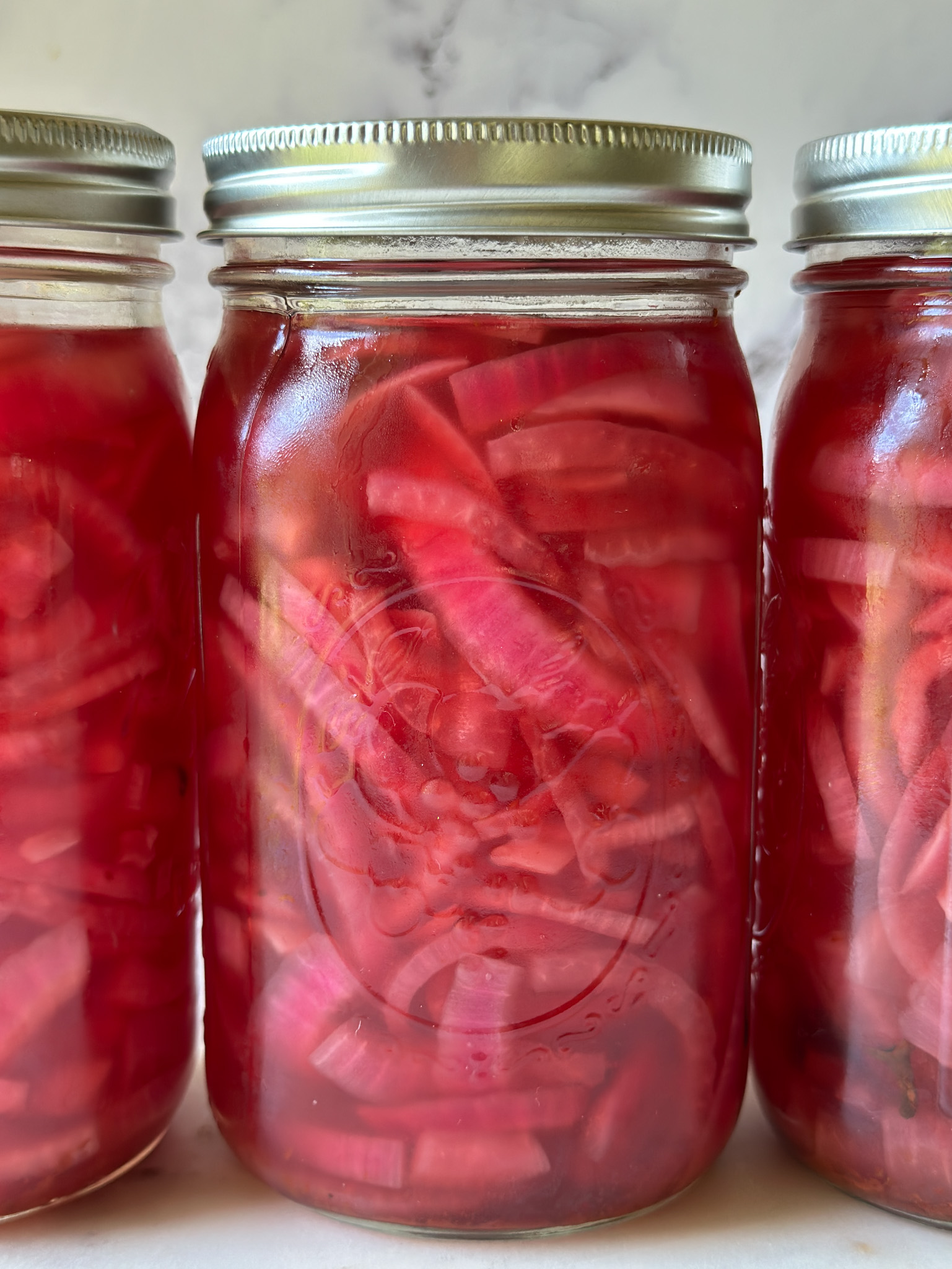 3 jars of vibrant pink pickled red onion