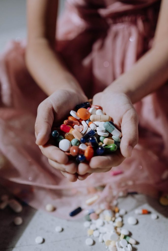 a handful of assorted medicines on a child s hands