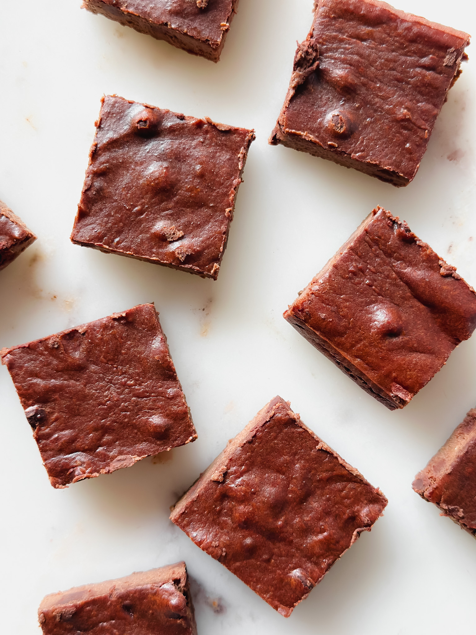 5 healthy, protein brownies on a marble backdrop